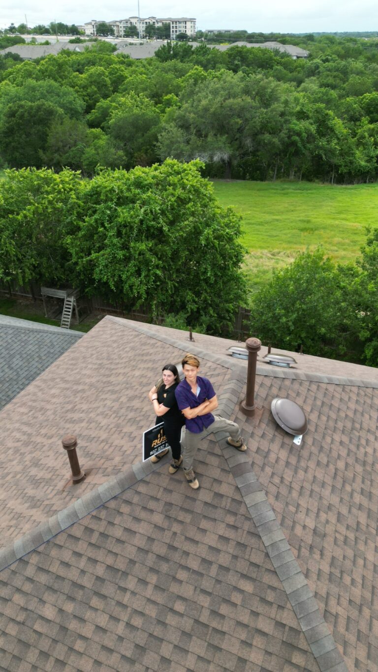 Rush Builders owners on a completed shingle roof in Austin